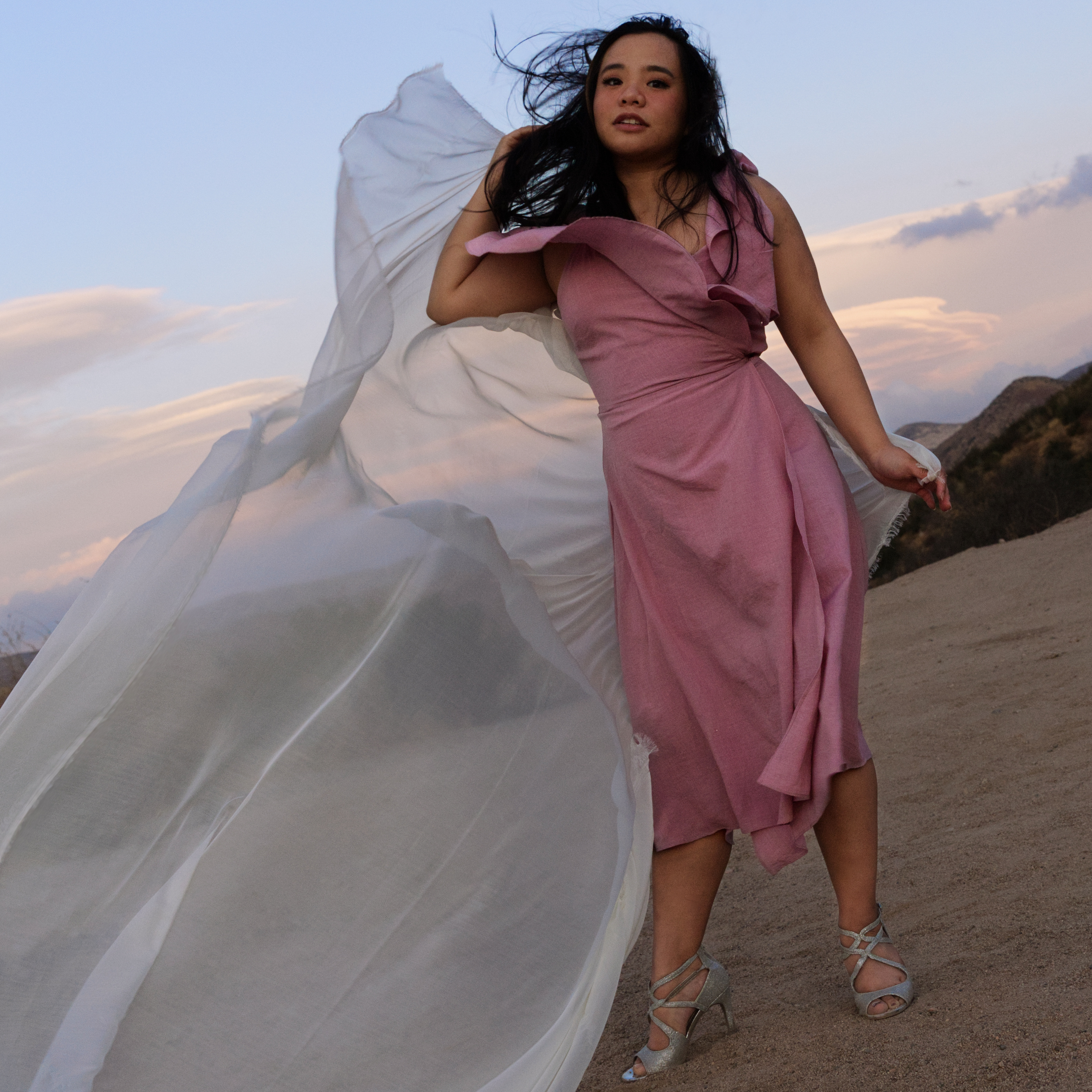girl holding a piece of cloth in the wind