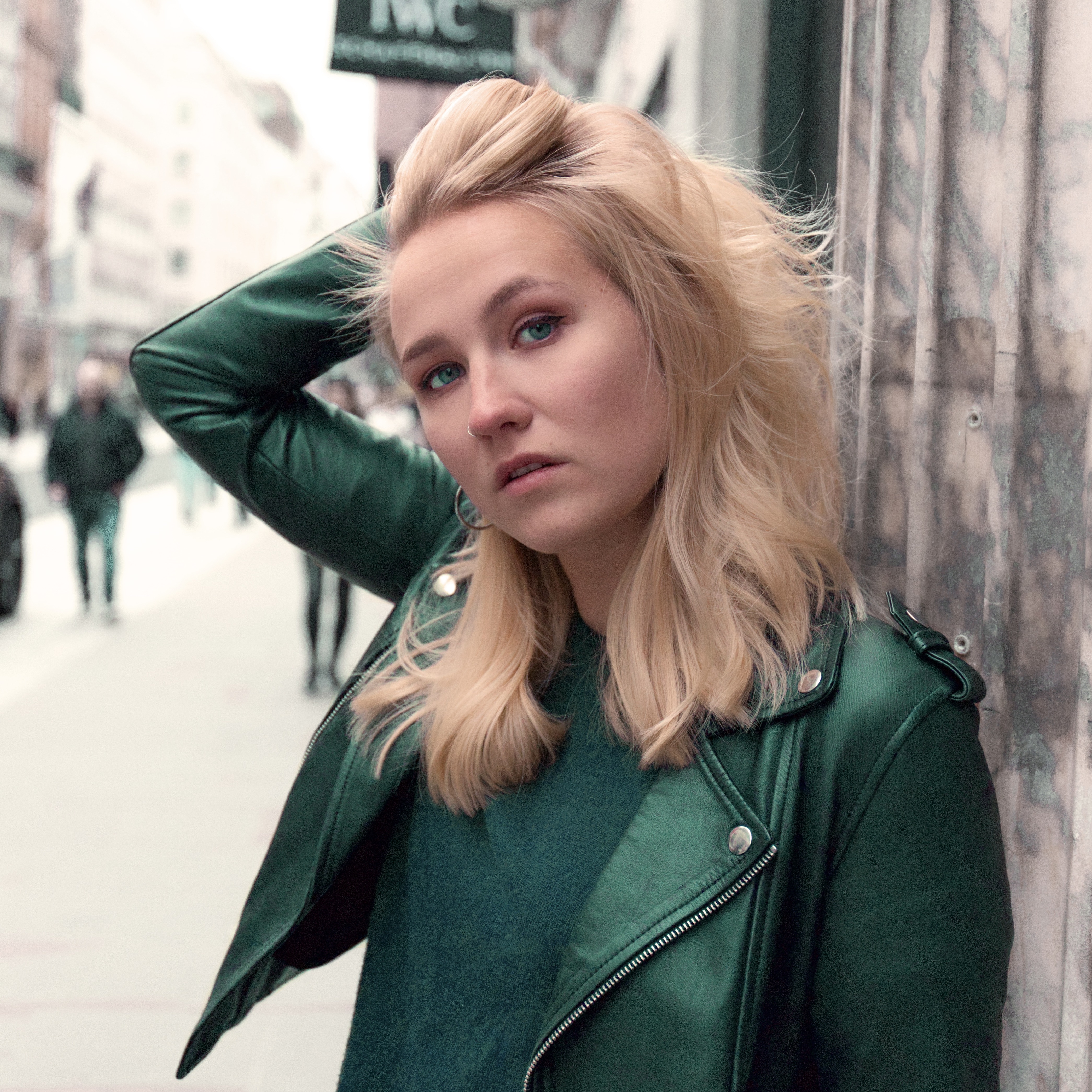 girl posing in front of a pillar on the streets of wayfair, London